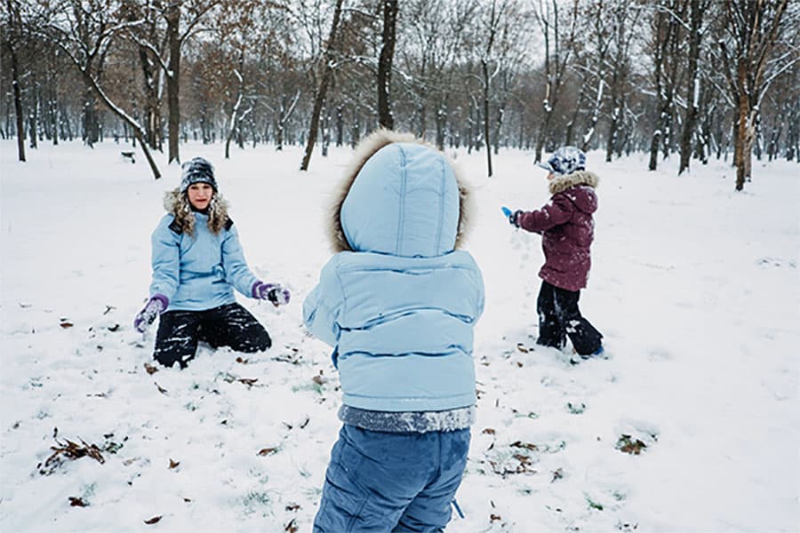 Teacher and children playing in the snow during recess